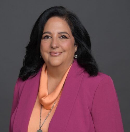 Smiling woman wearing magenta blazer and scarf